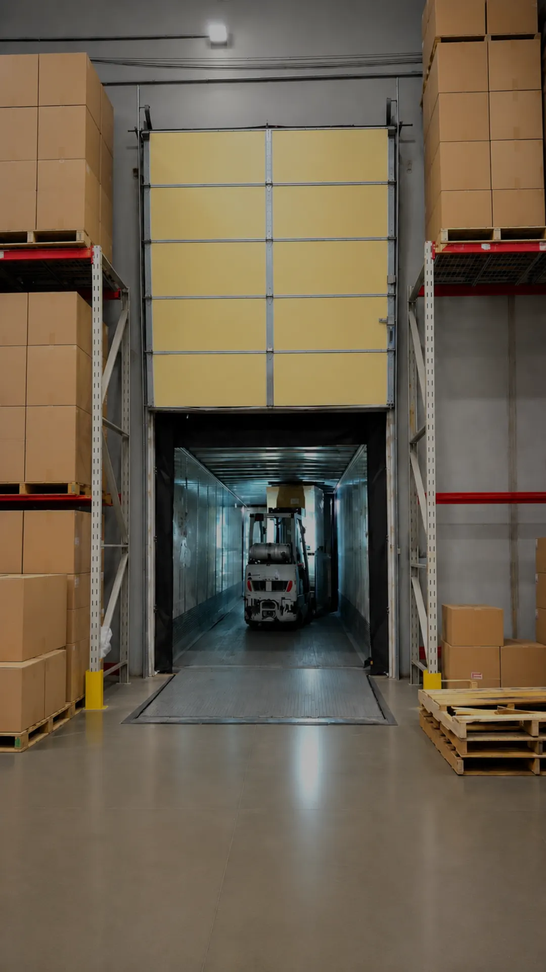 Forklift carrying a carton inside a trailer at the dock